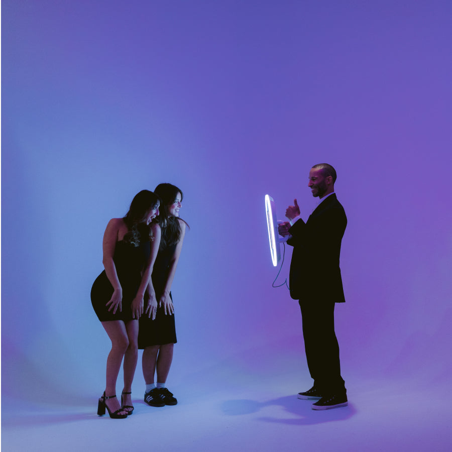 Guy and two young girls dressed formally and having fun with the Salsa two photo booth by PBSCO