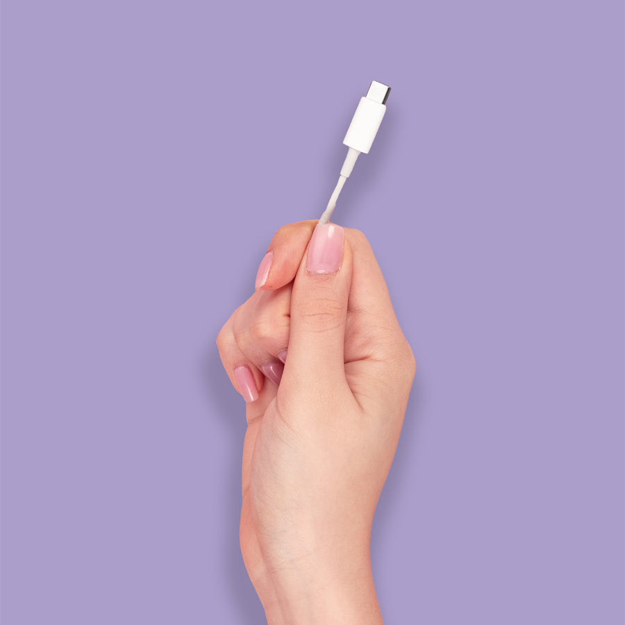 Power cord in hand on purple backdrop